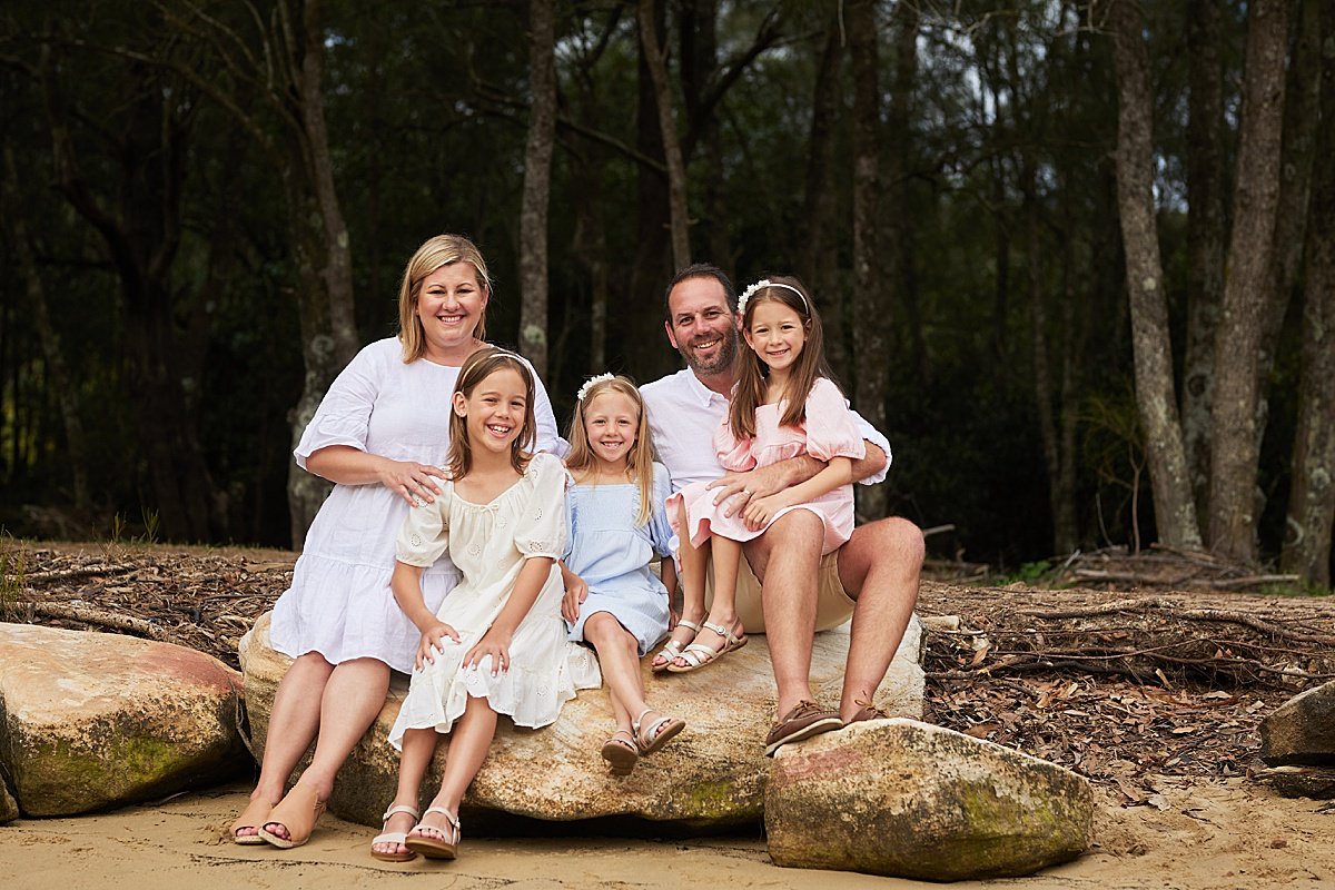 Outdoor park sitting on rocks family portrait with 3 girls