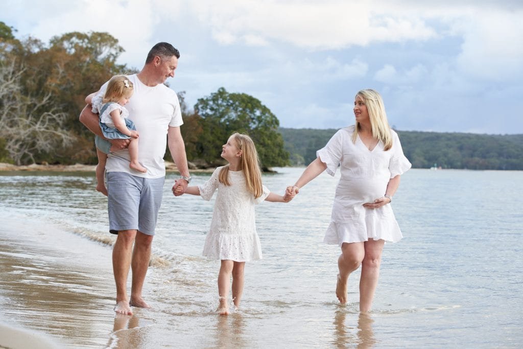 Family portrait on the beach in white and denim outfits