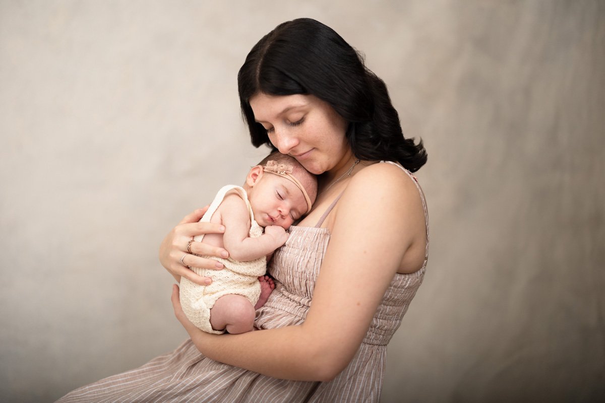 Mother and newborn baby daughter embracing