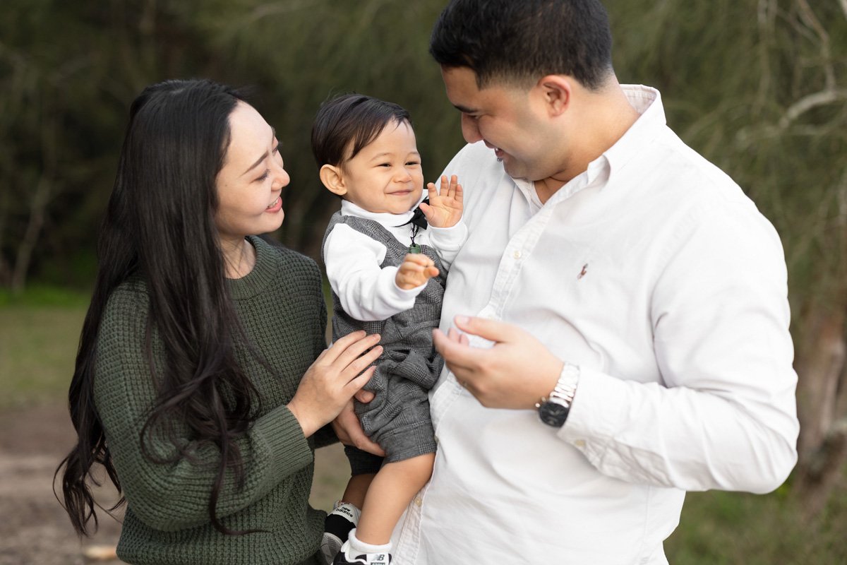 Outdoor family photo with parents and young son